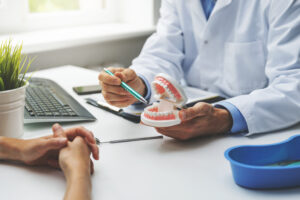 Dentist and patient discussing planned teeth treatment in dental clinic office