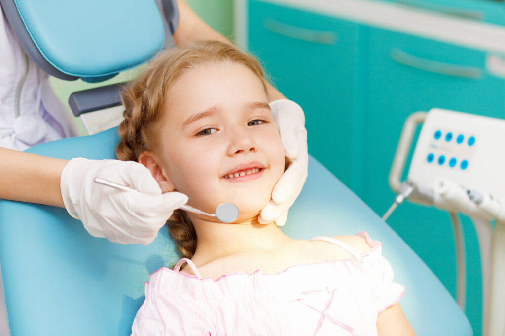Child receiving dental sealants treatment from a friendly dentist
