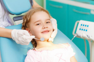 Child receiving dental sealants treatment from a friendly dentist